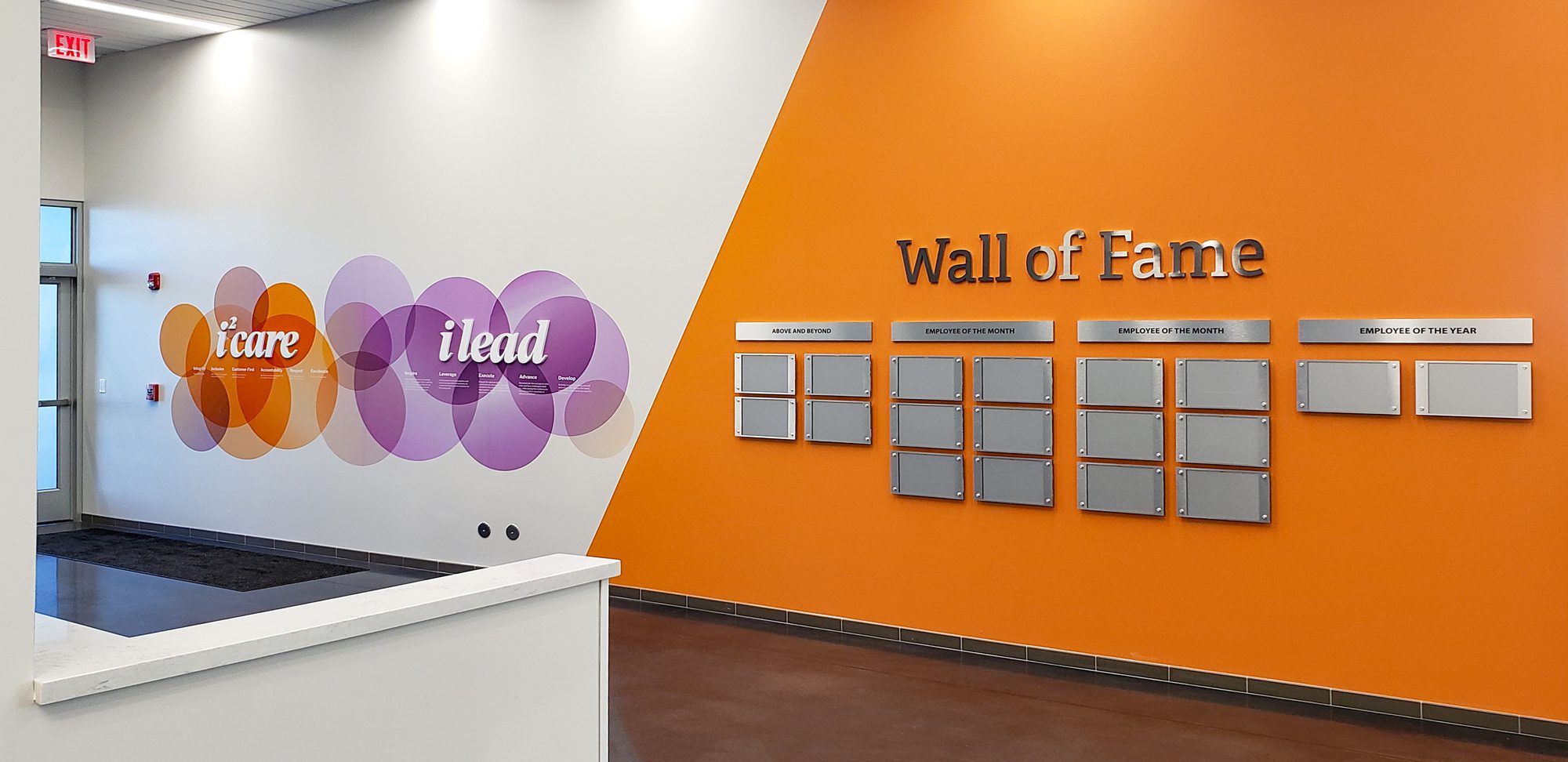 Custom environmental branding graphics, dimensional signs, and employee recognition display in a corporate office