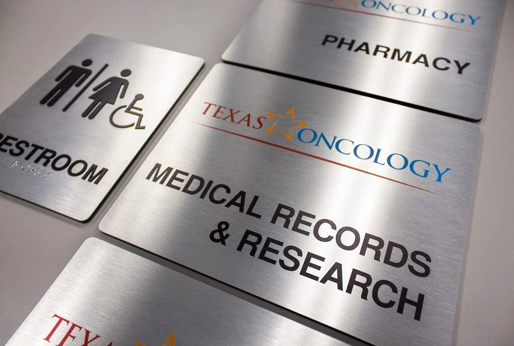 Custom interior and regulatory signage for identification and directional navigation in commercial buildings.