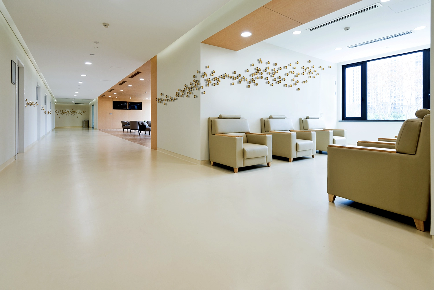 Creative wayfinding solution in a hospital featuring an arrangement of dimensional artwork leading down a hallway to enhance navigation