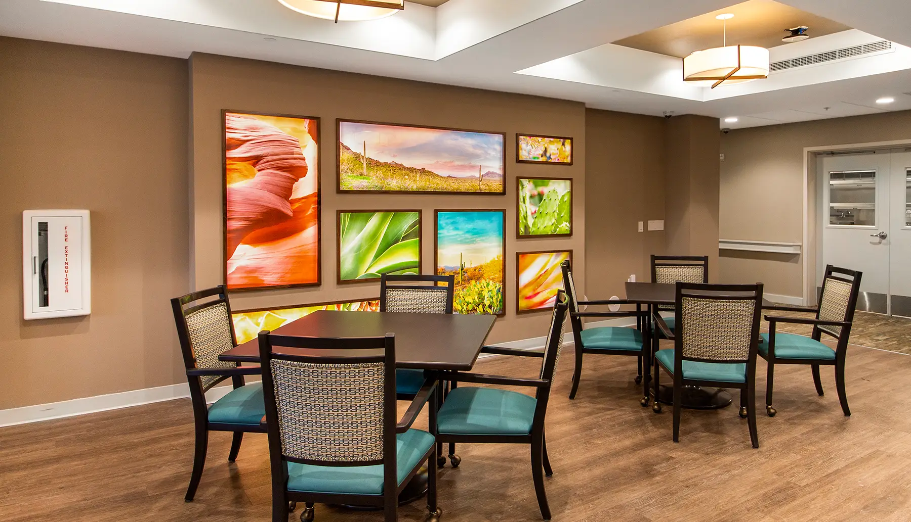 Illuminated gallery artwork display featuring backlit acrylic art prints in a senior living dining space.